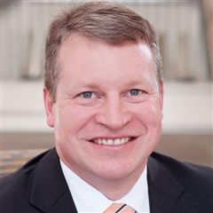 Headshot of a smiling white man in a tuxedo